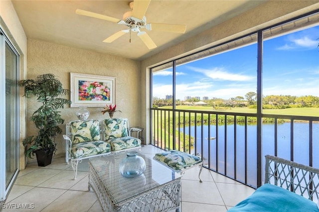 sunroom / solarium featuring a water view and a ceiling fan