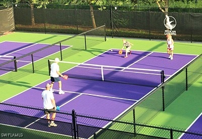 view of tennis court featuring community basketball court and fence