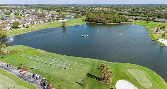 drone / aerial view with view of golf course and a water view