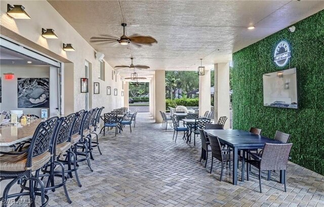 view of patio with outdoor dry bar, outdoor dining area, and a ceiling fan