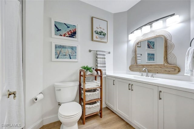 bathroom with vanity, toilet, and wood finished floors