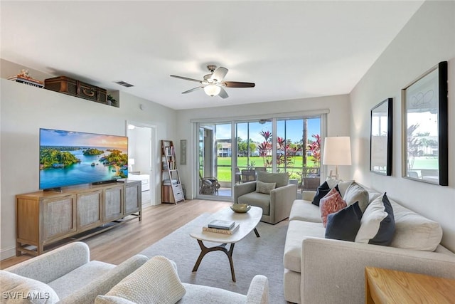 living area with light wood-style floors, visible vents, and ceiling fan