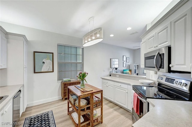 kitchen with light wood-style flooring, a peninsula, stainless steel appliances, and light countertops