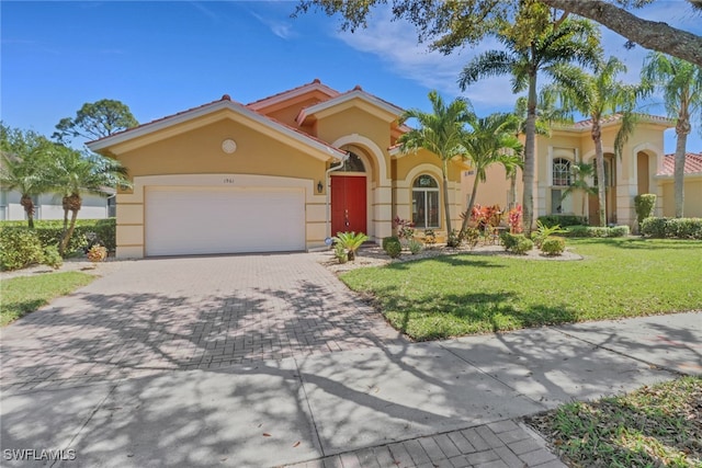 mediterranean / spanish home with stucco siding, decorative driveway, a front lawn, and an attached garage