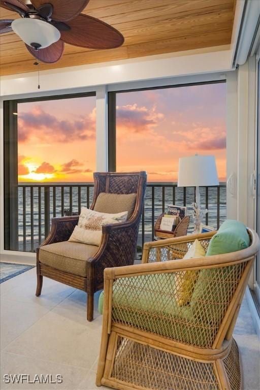 living area featuring a water view, wooden ceiling, a sunroom, ceiling fan, and tile patterned flooring