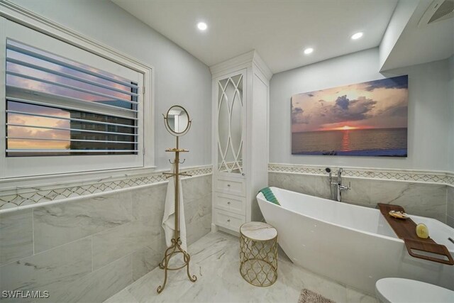 full bathroom featuring a freestanding tub, a wainscoted wall, visible vents, marble finish floor, and recessed lighting