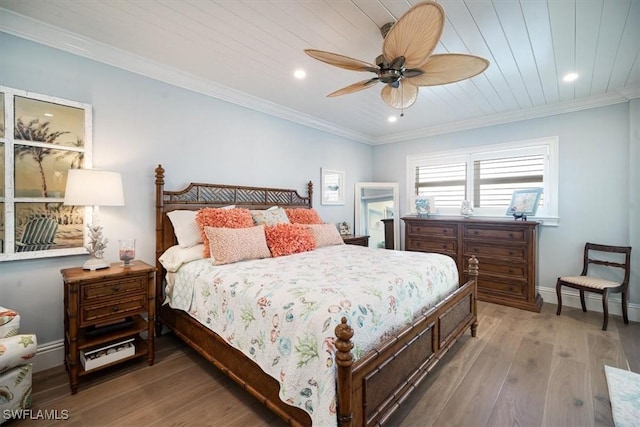 bedroom with recessed lighting, crown molding, baseboards, and wood finished floors