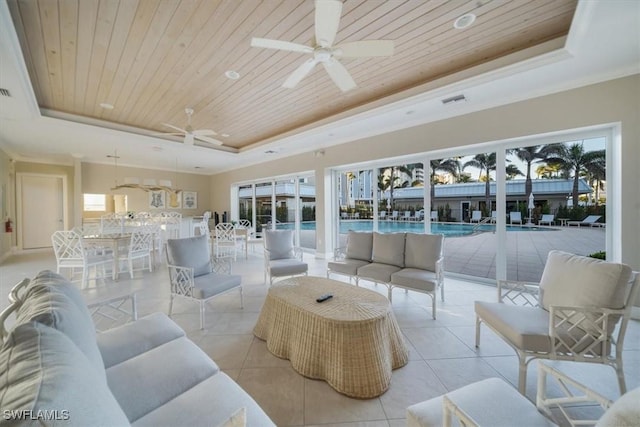 living room featuring a tray ceiling, light tile patterned floors, and wooden ceiling