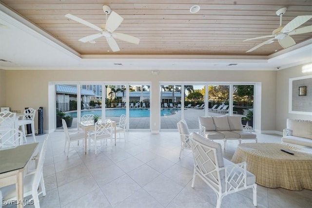 sunroom featuring ceiling fan, wooden ceiling, and a tray ceiling