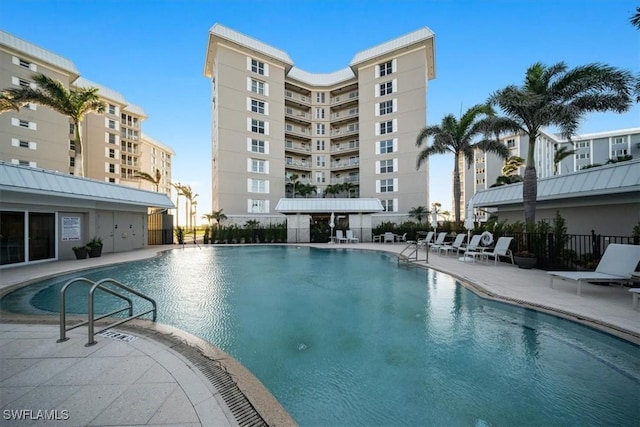 pool with a patio and fence