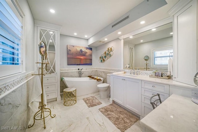 full bath featuring wainscoting, recessed lighting, a soaking tub, marble finish floor, and vanity