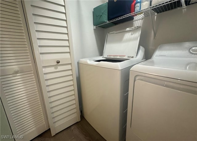 clothes washing area featuring separate washer and dryer, dark wood-style flooring, and laundry area