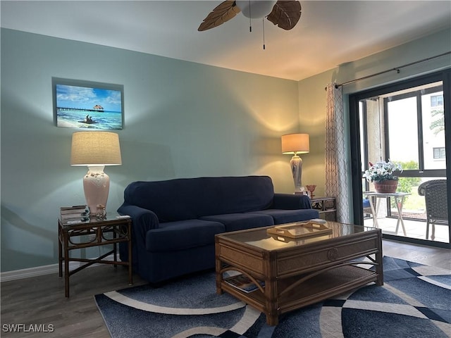 living area featuring ceiling fan, baseboards, and wood finished floors