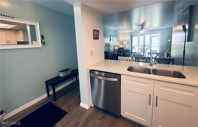 kitchen featuring a sink, stainless steel dishwasher, dark wood finished floors, and light countertops