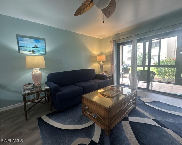 living area featuring baseboards, wood finished floors, and a ceiling fan