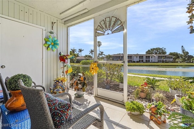 sunroom featuring a water view