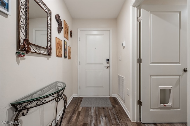 doorway featuring visible vents, baseboards, and dark wood-type flooring