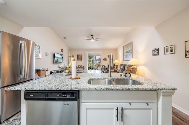 kitchen with a sink, light stone countertops, white cabinetry, and stainless steel appliances