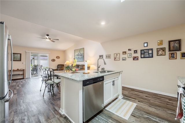 kitchen with dark wood-type flooring, an island with sink, white cabinets, stainless steel appliances, and a sink