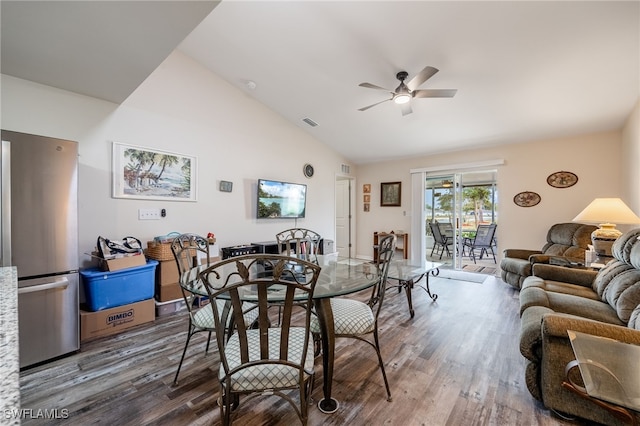 dining room featuring visible vents, lofted ceiling, wood finished floors, and a ceiling fan