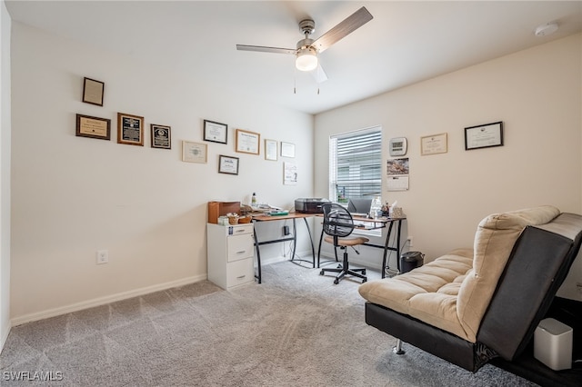 carpeted office featuring baseboards and ceiling fan