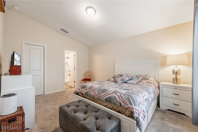 bedroom with visible vents, light carpet, connected bathroom, and vaulted ceiling