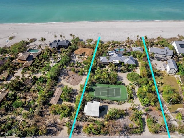 birds eye view of property featuring a beach view and a water view