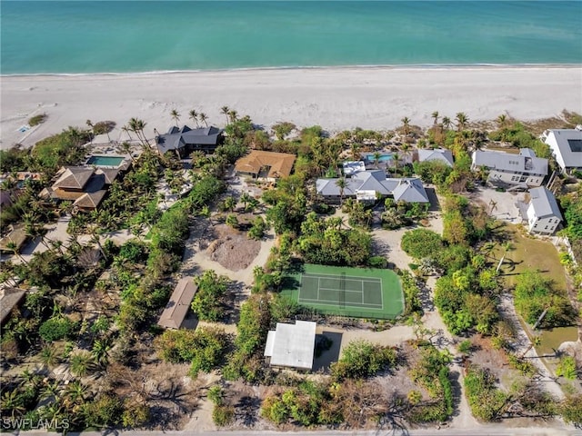 drone / aerial view featuring a view of the beach, a water view, and a residential view