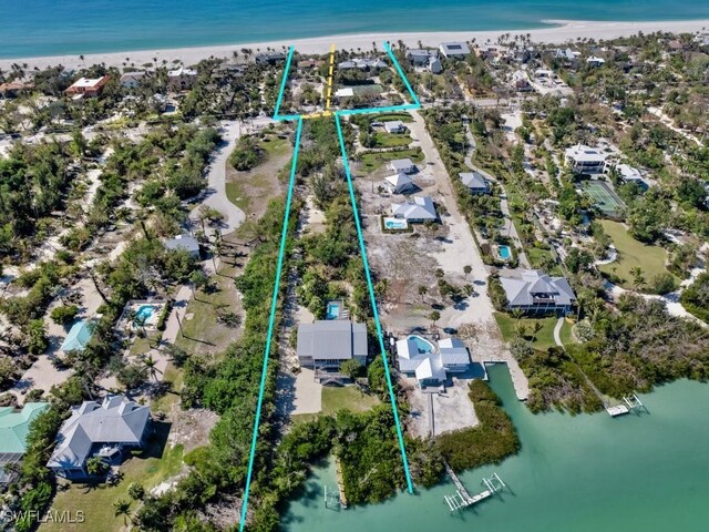 bird's eye view with a water view and a beach view