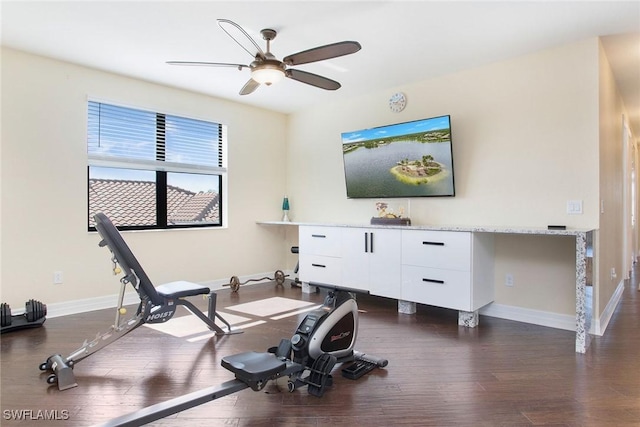 workout room with dark wood-style floors, a ceiling fan, and baseboards