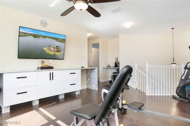 interior space featuring a ceiling fan, wood finished floors, visible vents, and baseboards