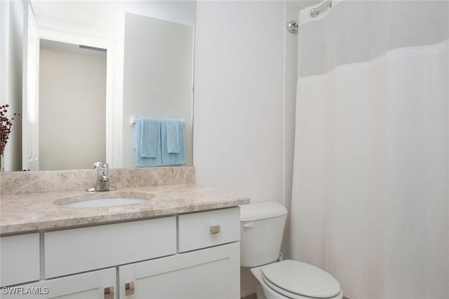 bathroom featuring curtained shower, toilet, and vanity