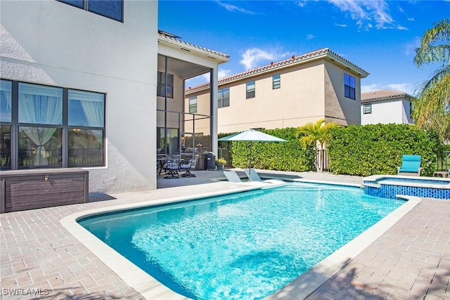 view of swimming pool with a patio area, fence, and a pool with connected hot tub