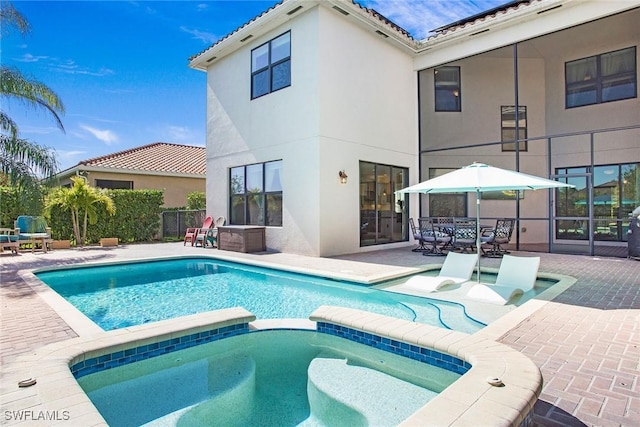 view of swimming pool featuring a pool with connected hot tub and a patio