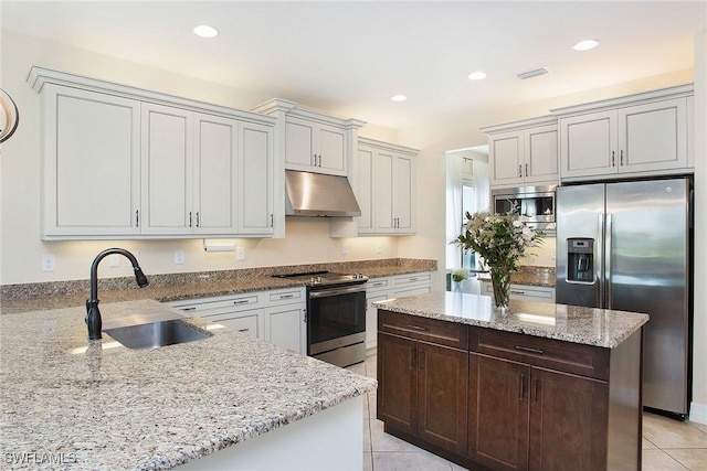 kitchen featuring light stone counters, recessed lighting, a sink, stainless steel appliances, and under cabinet range hood