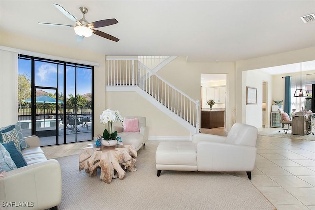 living room featuring visible vents, a ceiling fan, stairs, and tile patterned flooring