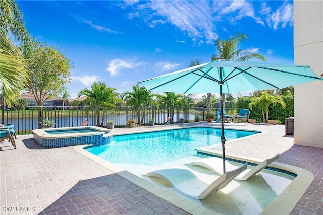 view of pool featuring a patio area, a water view, a pool with connected hot tub, and fence