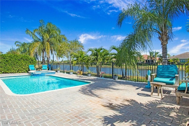 view of swimming pool featuring a patio area, a pool with connected hot tub, a water view, and fence