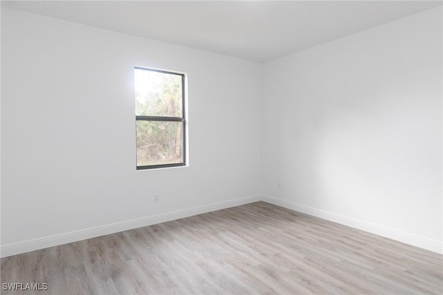 unfurnished room featuring baseboards and light wood-style floors