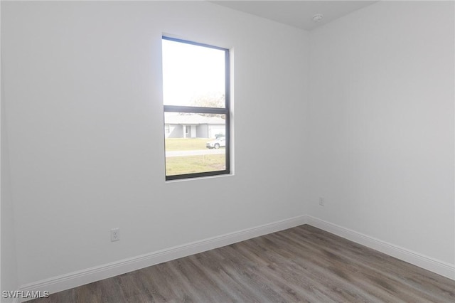 empty room featuring wood finished floors and baseboards