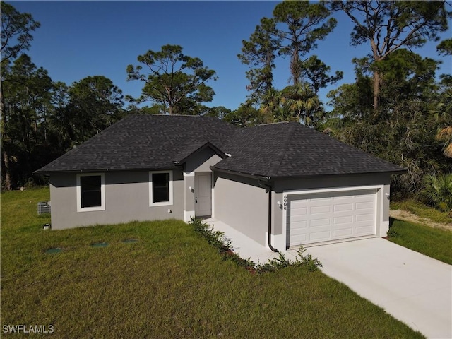 ranch-style home featuring a front yard, driveway, an attached garage, a shingled roof, and stucco siding