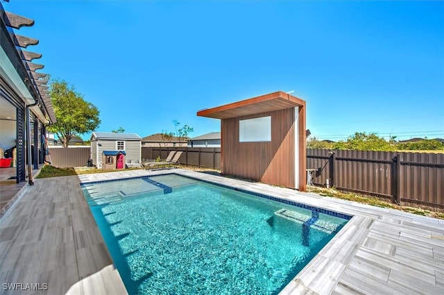 view of swimming pool with a shed, a fenced in pool, an outdoor structure, and a fenced backyard