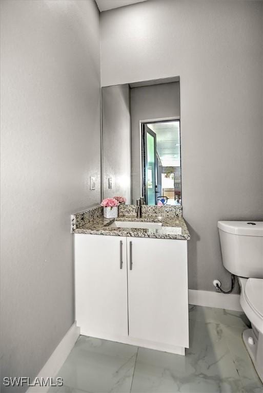 bathroom featuring baseboards, toilet, marble finish floor, and vanity