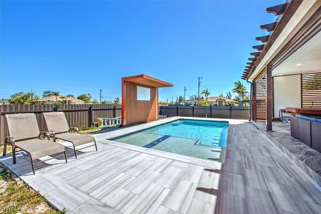 view of pool featuring a fenced in pool, a patio, an outbuilding, and a fenced backyard