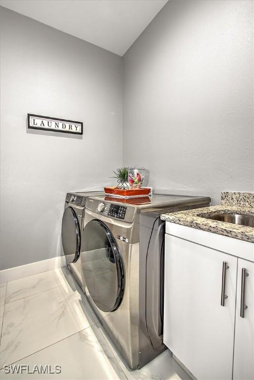 laundry area with cabinet space, marble finish floor, baseboards, and separate washer and dryer