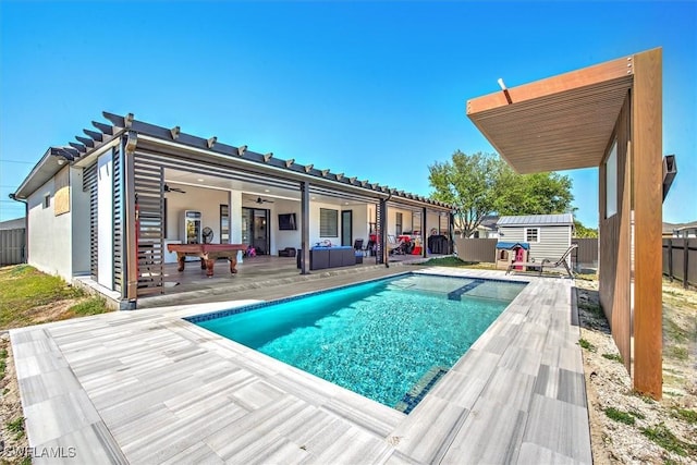 view of pool featuring a fenced in pool, ceiling fan, fence, a storage shed, and an outdoor structure