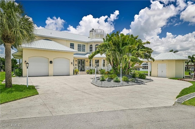 view of front of house featuring stucco siding, metal roof, decorative driveway, and a garage