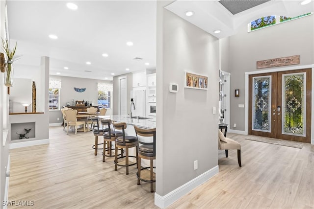 foyer entrance featuring recessed lighting, light wood-style floors, baseboards, and french doors