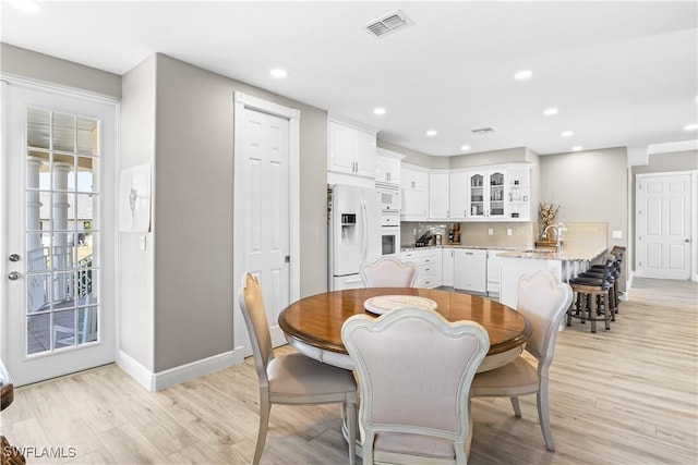 dining area featuring light wood-style flooring, recessed lighting, and baseboards