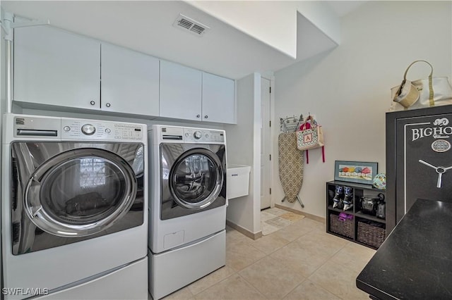 clothes washing area featuring visible vents, baseboards, light tile patterned floors, cabinet space, and separate washer and dryer